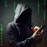 image of person in a hoodie with face not visiable holding a phone
