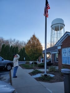 photo of Vic Ater saluting the flag at Natco's main office