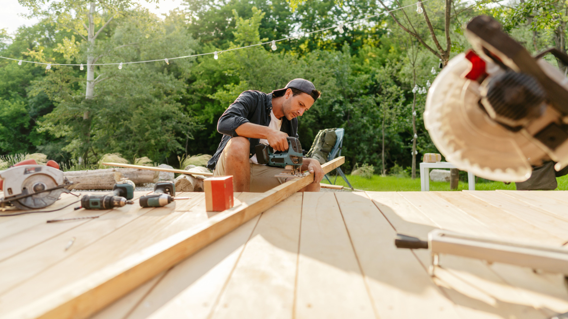 man building deck in backyard