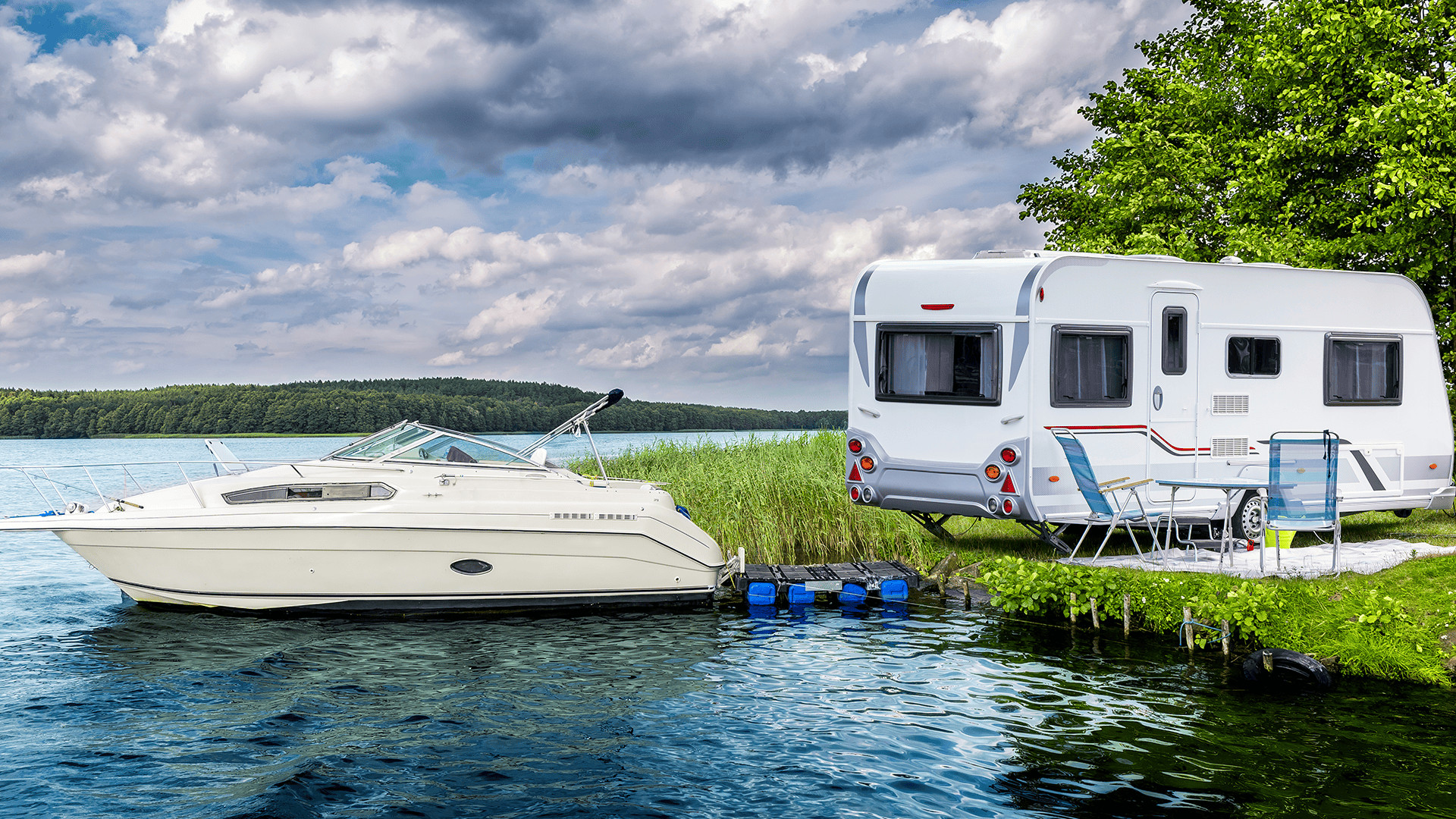 rv and boat at lake