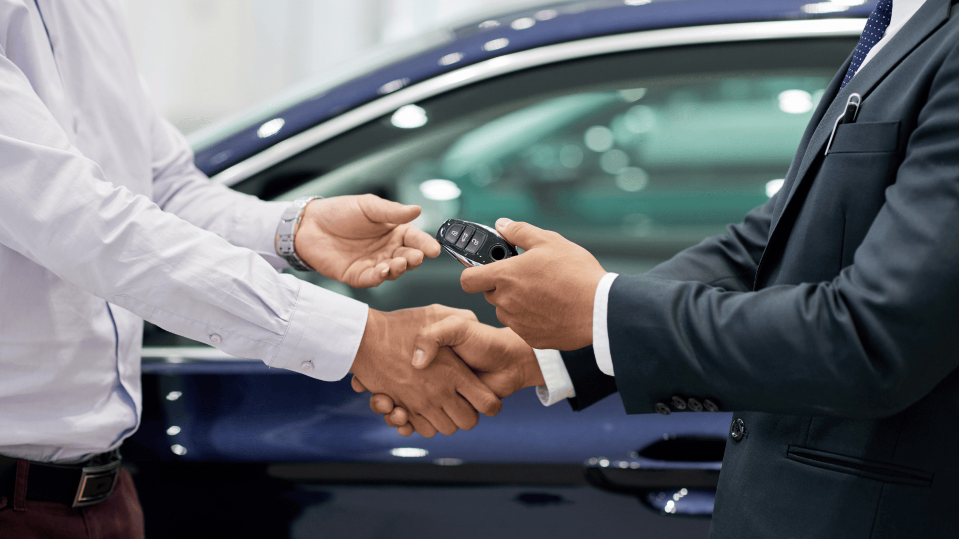 two people shaking hands and exchanging car key