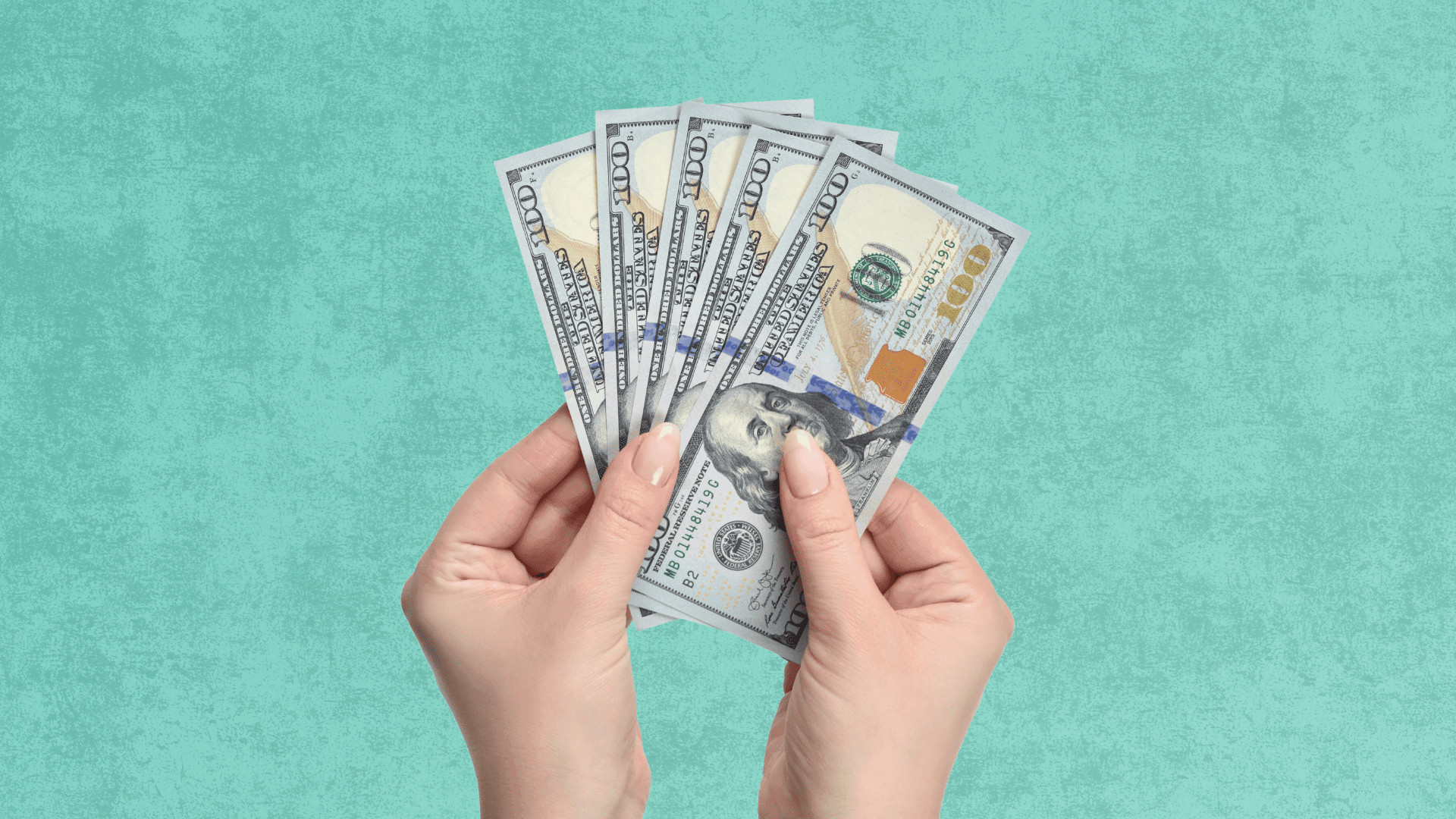 close up of someone holding 5 $100 bills