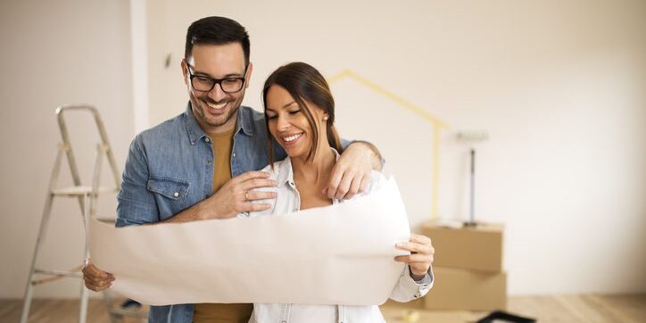 young couple looking at blueprint