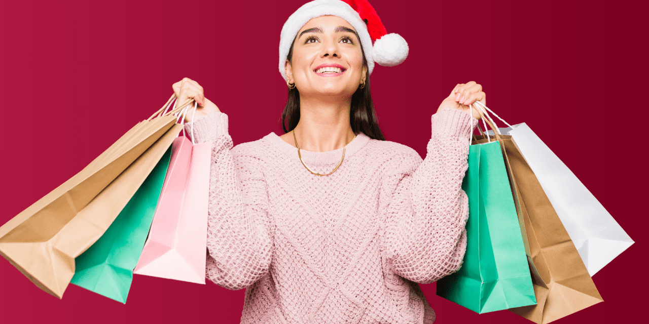women wearing a santa hat and holding several gift bags