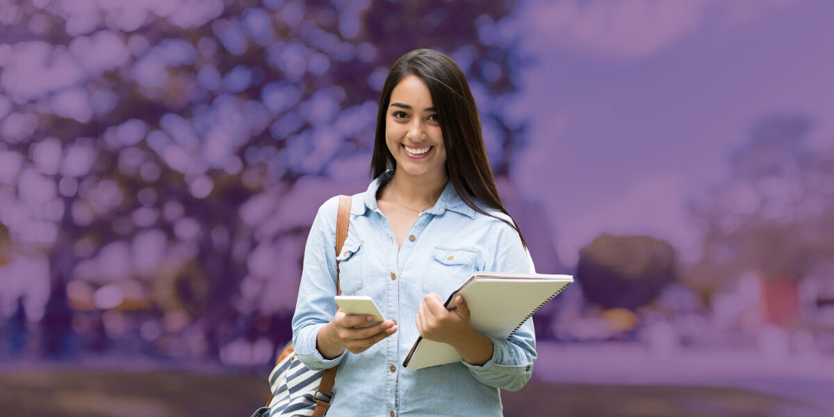 student with notebook and cell phone